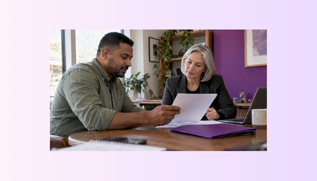 An image of a broker discussing a documents with a women, representing the title, "How mortgage brokers get paid".
