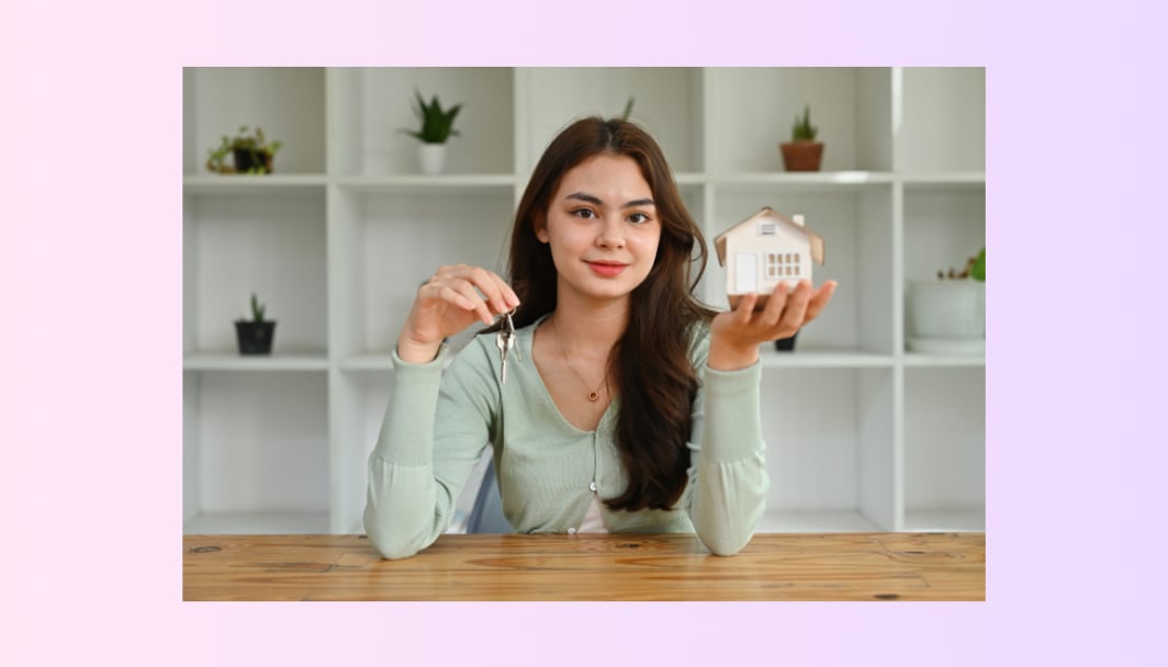 A lady holding a house in her hand, representing the topic, "Lenders Mortgage Insurance".