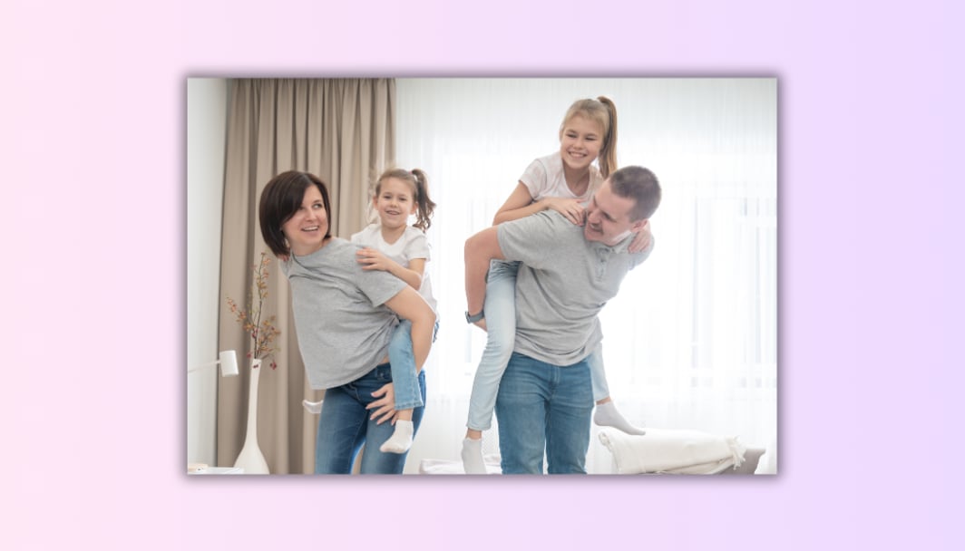 The image shows a happy couple playing with their kids.