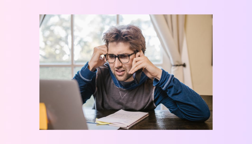 A young guy on a phone, looking at a screen with a frustrated expression.